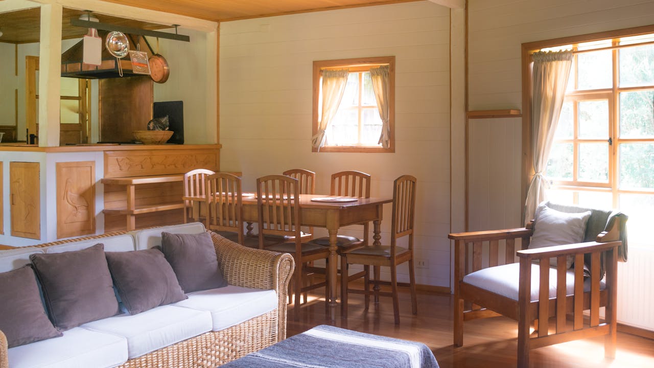 Warm and inviting home interior featuring a wicker couch and wooden dining area.